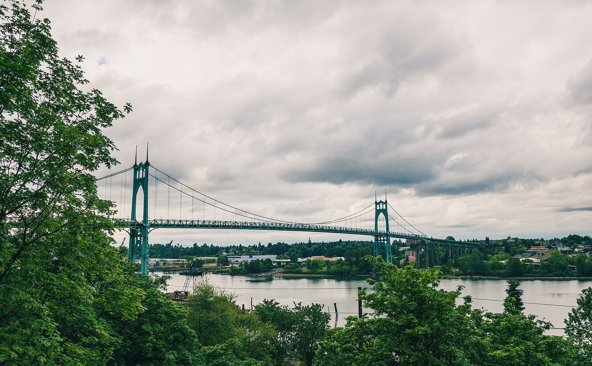 St. Johns Bridge framed by trees above the Willamette River in Portland, Oregon.